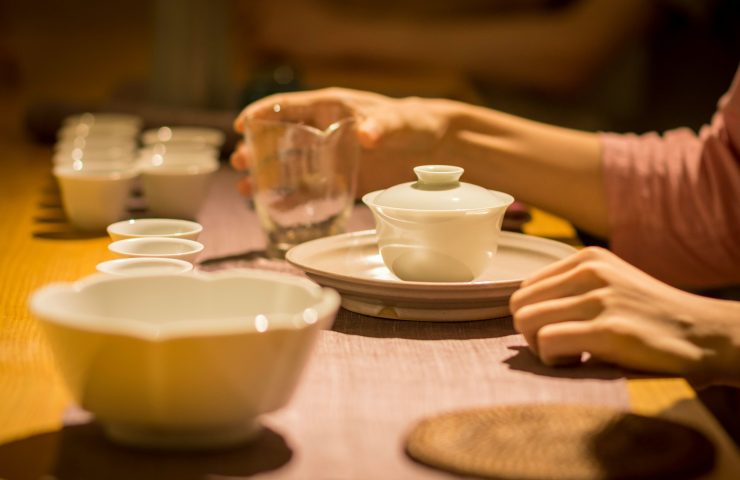 Hands preparing tea at a shared table, expressing tranquility, home rituals, and mindful nourishment